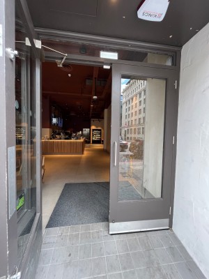 Double glass doors in brown pls set if frame. Pull silver metal handles from centre to open.