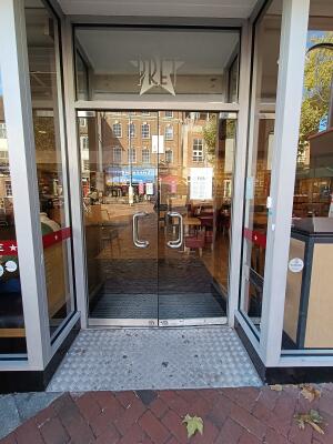 Glass doors with grey, wooden frame. Pull from silver handles in middle to open.