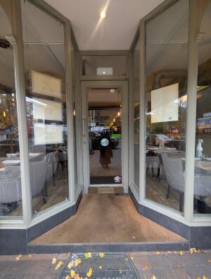 White frame archway in front. Glass door at back. Silver handle on left. Pull to open.