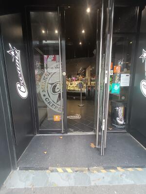 Glass door with black frame. Pull silver handles in middle to open.
