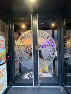 Black framed glass door. Pull silver metal long handle from centre to open.