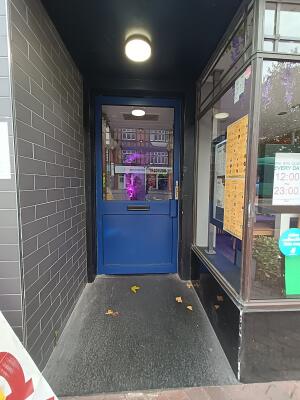 Glass door with blue frame. Pull from handle on right to open.