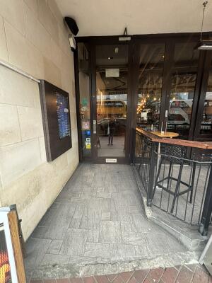 From street facing entrance. Pathway ahead to brown glass door ahead.