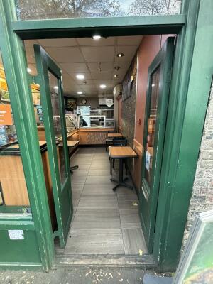 From street facing venue. Green framed glass doors ahead. Doors open from centre inwards.