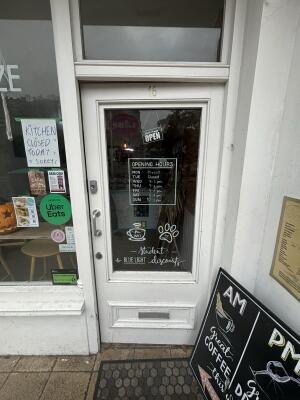 From street facing venue. White framed glass door ahead. Push door from left to open inwards.