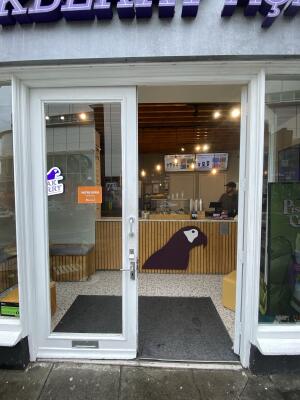 White framed glass door. Turn and push silver metal handle from centre to open.