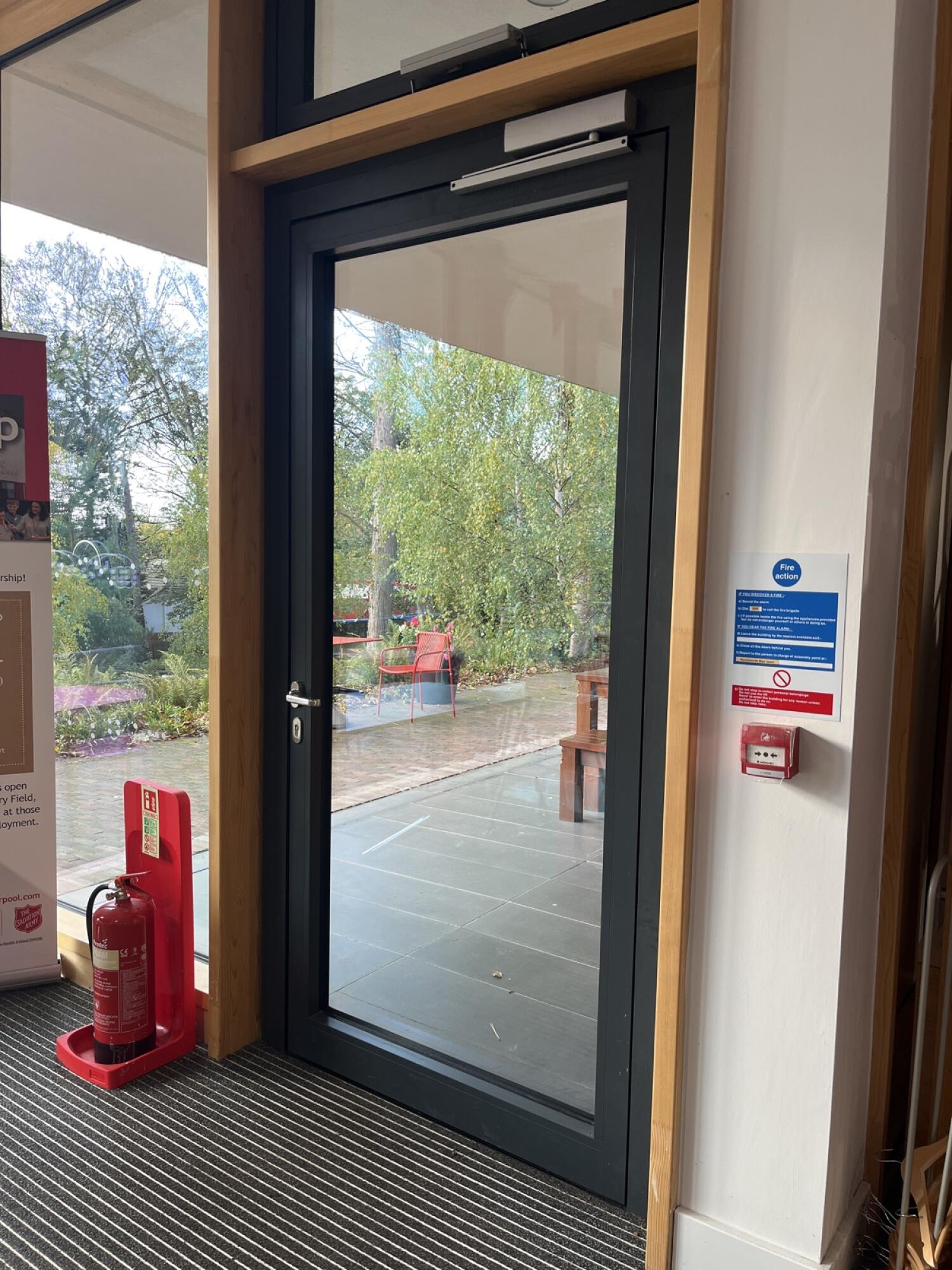 Black metal-framed glass door. Pull from handle on left to open.