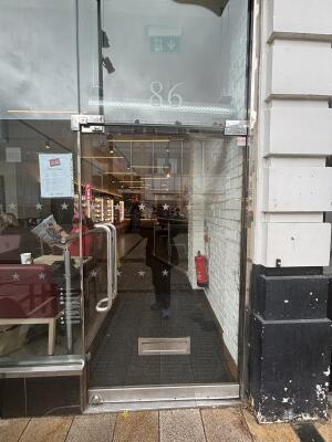 From street facing venue. Glass foot ahead. Push metal handle on left to open.