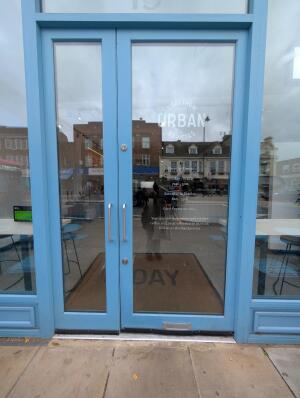 Blue frame glass doors in front. Silver handles on left middle. Push to open.