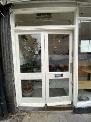 White framed glass door. Push from right to open.