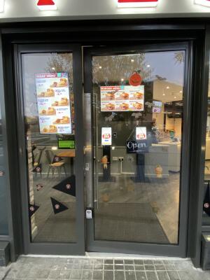 Black framed glass door. Push from left to open.