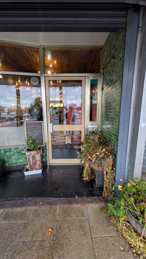 Glass door with metal frame. Pull handle on left to open