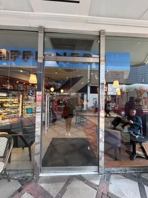 Silver frame glass doors in front. Silver handle on left. Push to open.