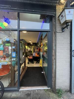 Glass door with a grey frame. Metal handle on left. Push to open.