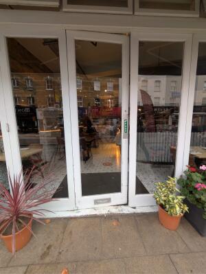 Glass door with white wooden frames ahead. Push from right to open.