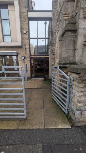 From street facing venue. Metal gates ahead. Push in center to open