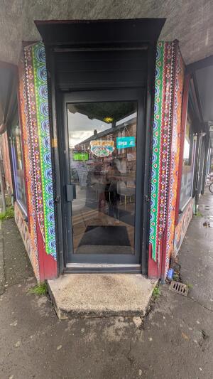 Glass door with black frame. Push handle on left to open
