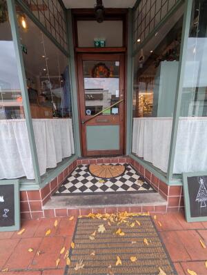 Archway in front. Door at back. Glass door with brown wooden frames at back. Push handle on right to open.