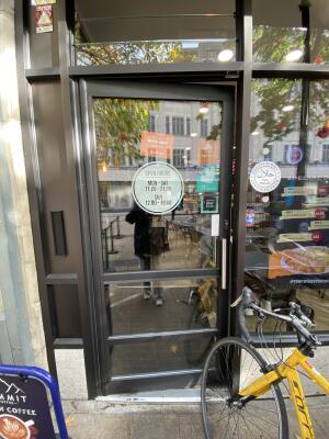 Black framed glass door. Push from right to open.
