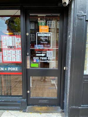 Black framed half panel glass door ahead. Push on left to open.