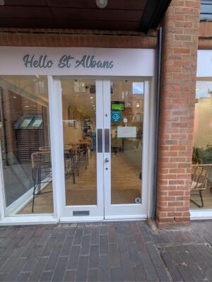 Glass doors with white wooden frames ahead. Push from center to open.