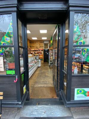 Glass door with black metal frames ahead. Push handle on left to open.