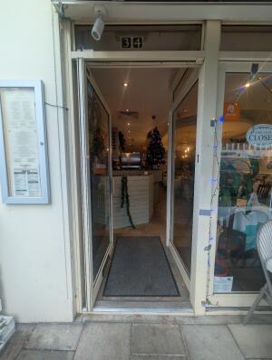 White frame glass doors in front. Metal handle on right. Push to open.