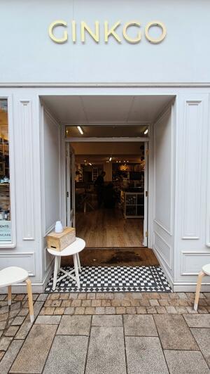Glass doors with white wooden frame. Push from centre to open. Table on left slightly obstructing door.
