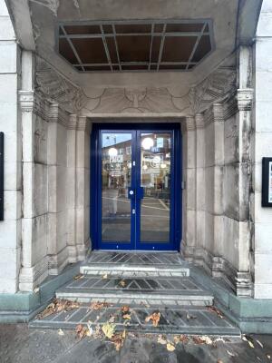 Cement archway in front. Blue frame glass doors at back. Metal handle in center. Pull to open.