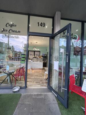 Glass door with grey frames ahead. Pull from left to open.