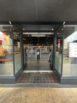 From street facing venue. Opening ahead.  Glass doors at back. Pull handles from centre to open.
