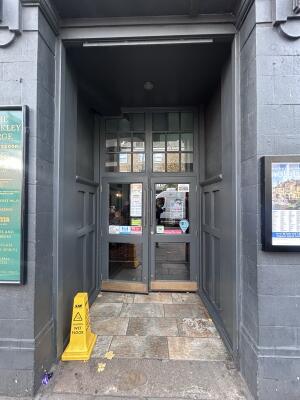 From side walk facing venue. Archway ahead. Door at back.