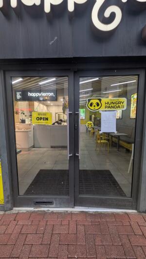 Glass doors with grey frames. Push handle in center to open.