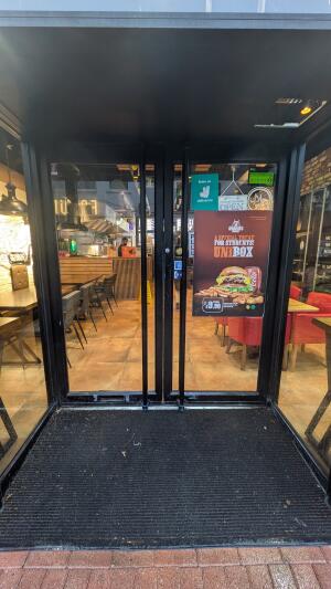 Glass doors with black frame. Push handle in center to open