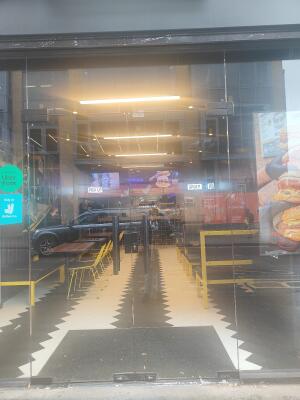 From sidewalk facing venue. Glass door ahead. Push black handle in centre to open.