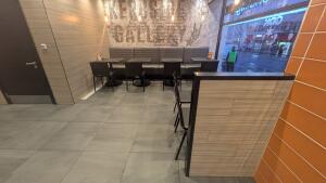 From entrance facing straight. Half booths, tables and chairs along back and right.