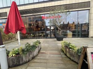 From sidewalk facing venue. Planters on left and right. Opening in centre.