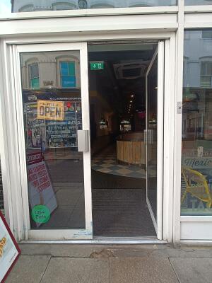 White metal-framed glass door with silver handles in middle. Push to open.