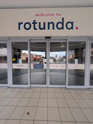 Grey frame glass doors in front. Doors open automatically to sides.