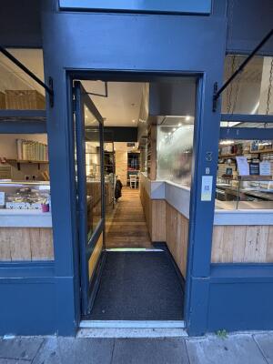 Blue metal-framed glass door. Push from handle on right to open.