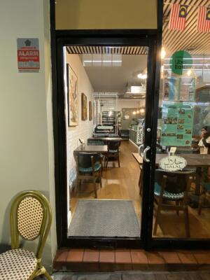 Black framed glass door. Push silver metal handle from right to open.