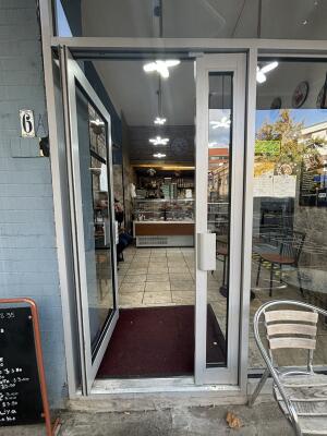 Metal framed glass door. Push handle in centre to open.
