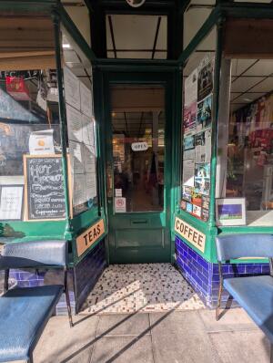 Green frame archway in front. Green frame glass door at back. Gold handle on left. Pull to open.