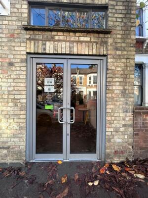 Grey framed double glass doors ahead. Push grey handle in centre to open.