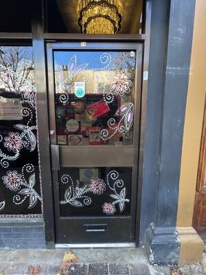 Black glass door ahead. Push black bar on left to open.