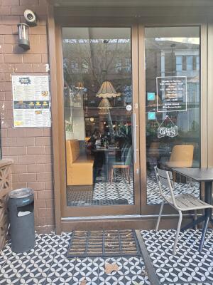 Brown framed glass door ahead. Push silver handle on right to open.