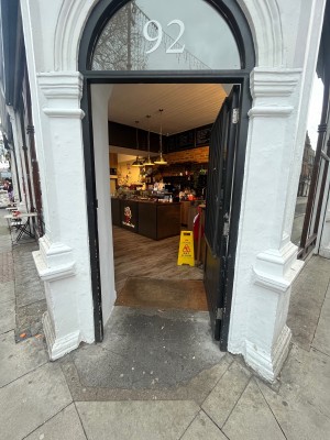 Glass door with black wooden frame. Push from left.