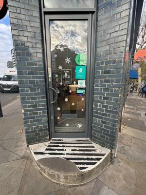 Black framed glass door ahead. Pull handle from left to open.