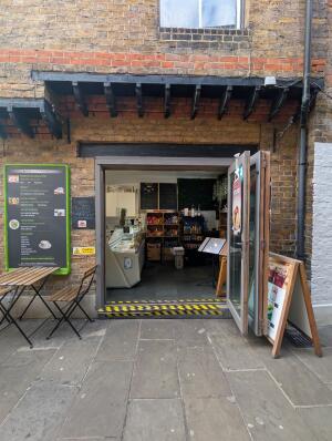 Brown frame glass folding door in front. Handle on left. Pull from left to right to open.