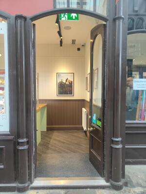 Brown framed half glass door ahead. Push golden knob on left to open.
